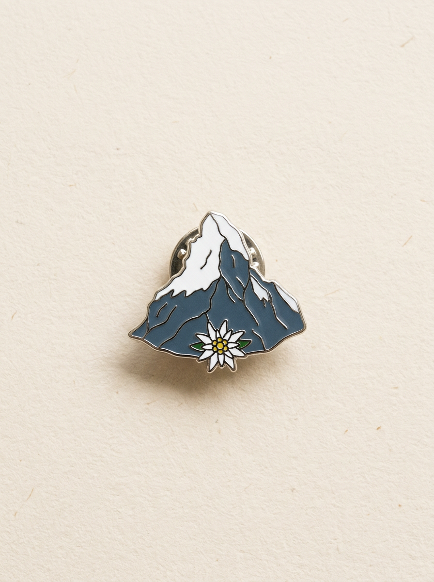 Pin émaillé d'un sommet enneigé avec une fleur d'edelweiss