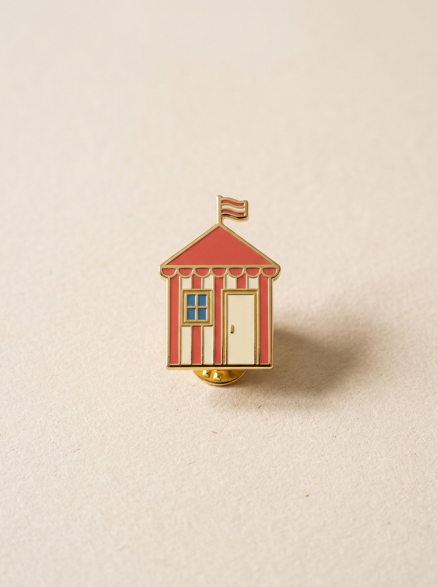 Pin émaillé d'une cabine de plage rayée rouge et crème avec un drapeau